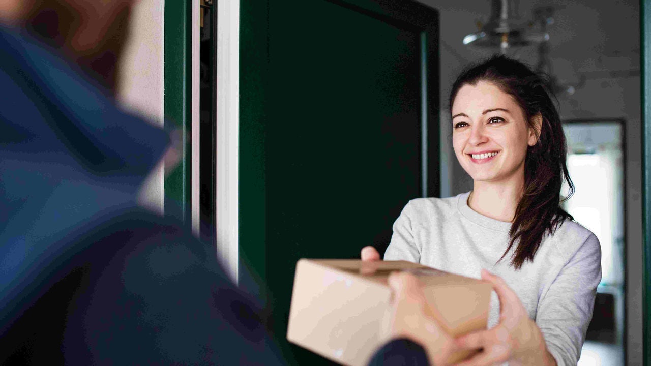 Eine junge Frau erhält ein Paket.