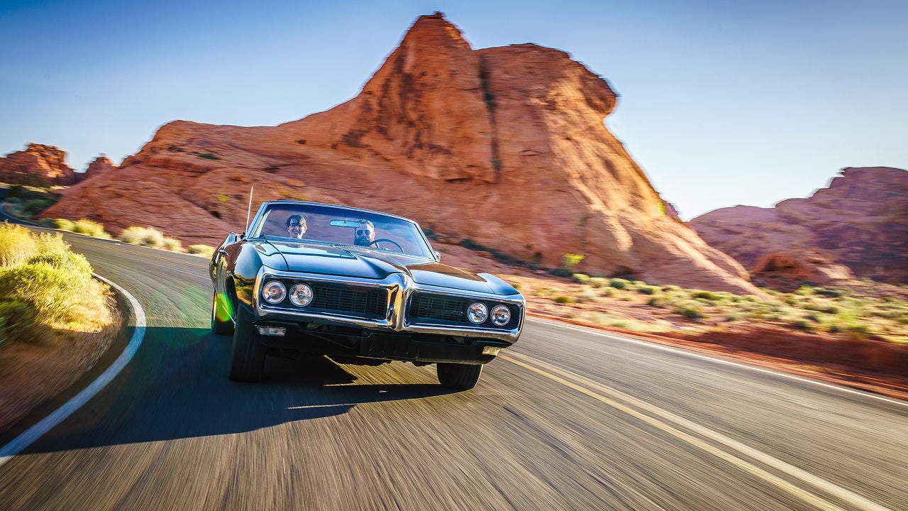 Zwei Männer fahren mit einem Oltimer durch den Grand Canyon