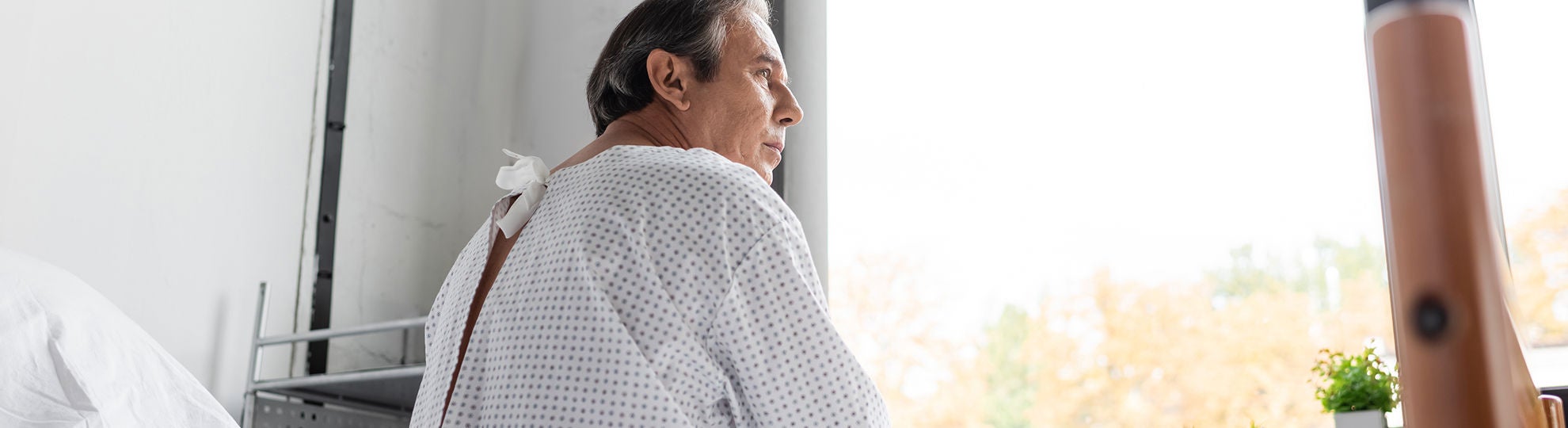 Ein Mann sitzt im Krankenhaus auf seinem Bett und schaut aus dem Fenster, Bildquelle: ©Adobe Stock/LIGHTFIELD STUDIOS 