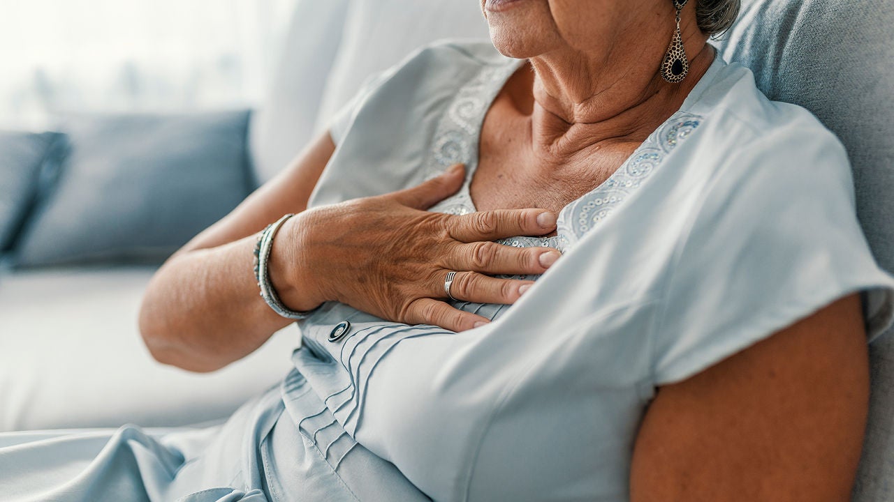 Frau in hellem Kleid, die eine Hand fest auf die Mitte ihrer Brust legt, ihr Oberkörper ist sichtbar, Gesicht nicht ganz im Bild, Bildquelle: ©Adobe Stock/Dragana Gordic