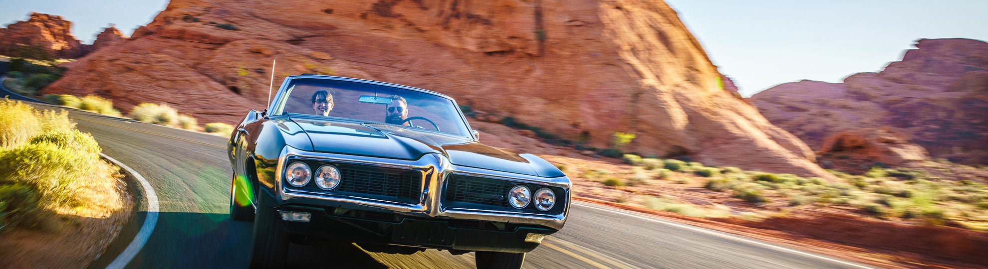 Zwei Männer fahren mit einem Oltimer durch den Grand Canyon