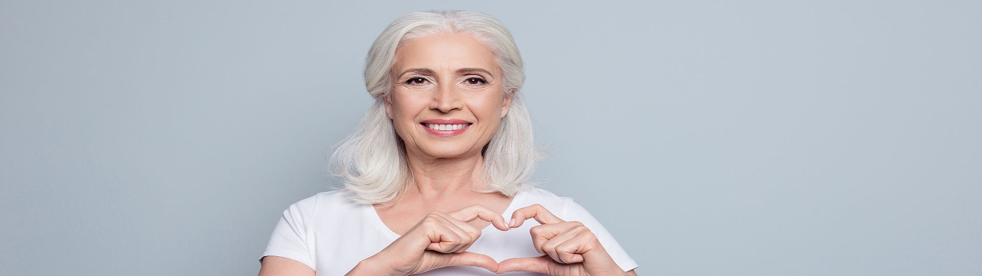 Frau mittleren Alters formt ein Herz