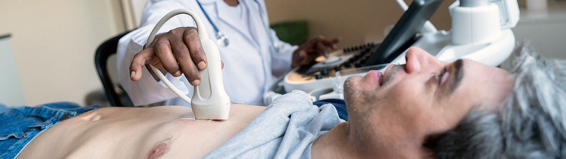 Ein Arzt untersucht mit einem Herz-Ultraschall einen Patienten.