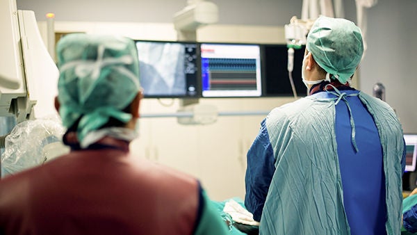 Behandelnde Ärzte bei Herzkatheteruntersuchung schauen auf Bildschirm