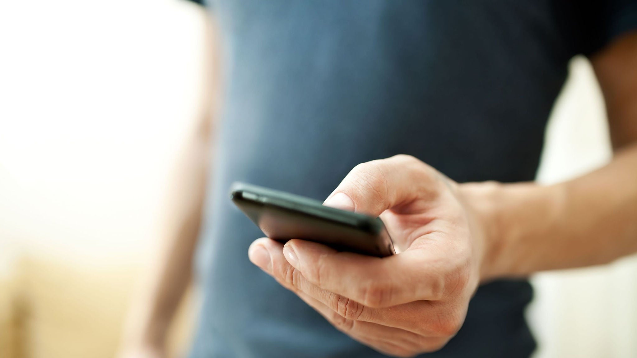 Ein Mann bedient sein Handy.