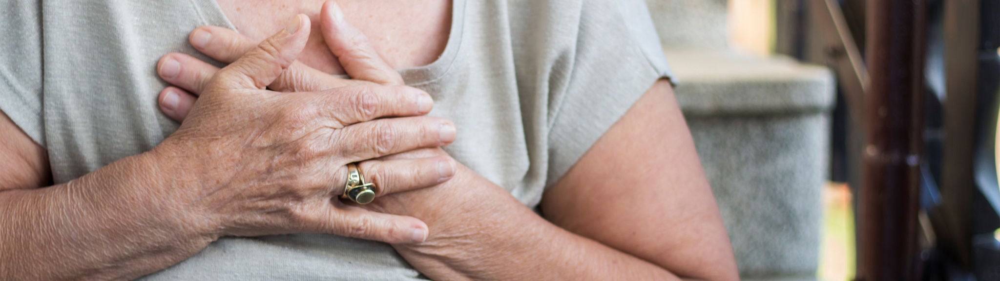 Eine Frau hält ihre Hände an die schmerzende Brust