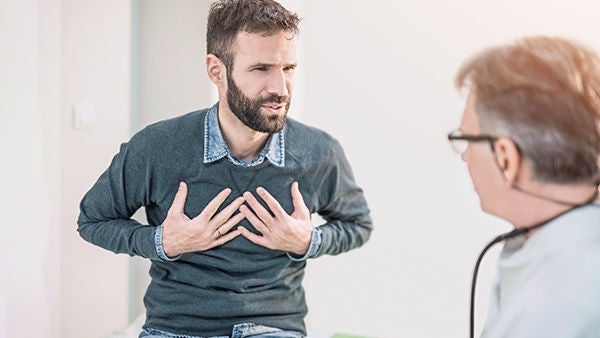 Ein Mann erklärt einem Arzt sein Herzrasen.