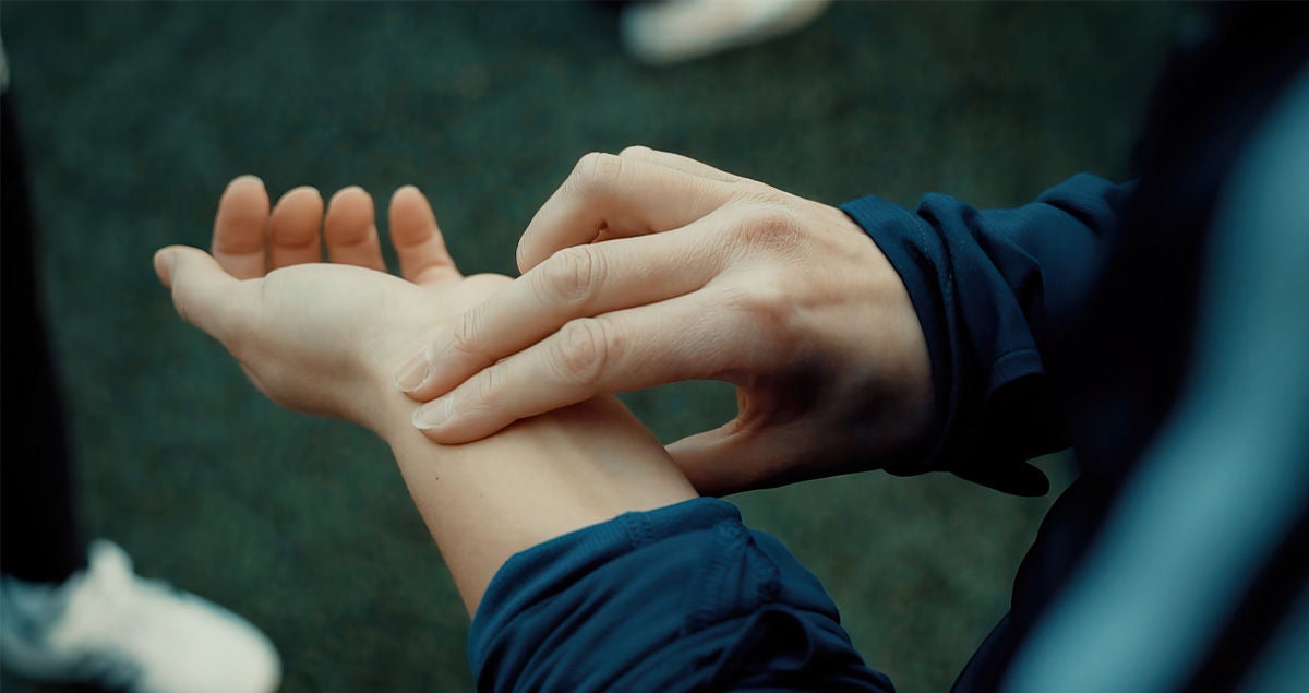 Eine Person misst an ihrer linken Hand mit Mittel- und Zeigefinger den Puls. Bildquelle: Deutsche Herzstiftung