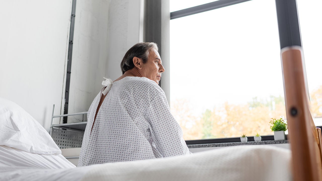 Ein Mann sitzt im Krankenhaus auf seinem Bett und schaut aus dem Fenster, Bildquelle: ©Adobe Stock/LIGHTFIELD STUDIOS 