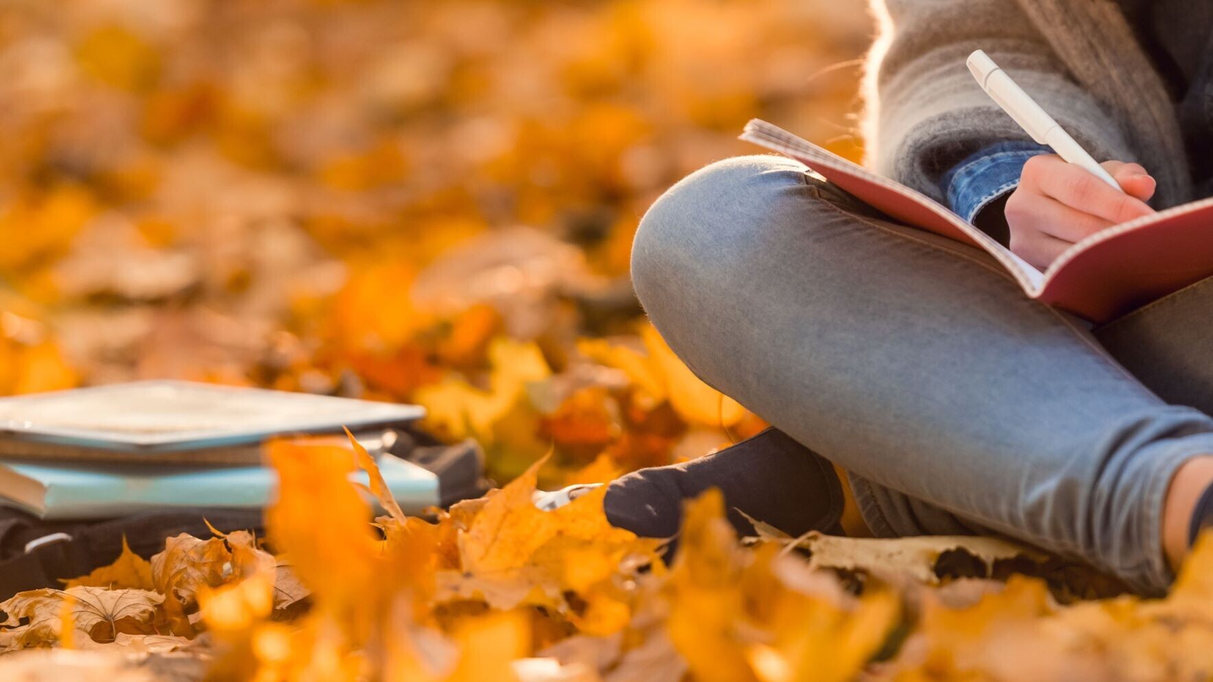 Frau sitzt in Laub auf dem Boden