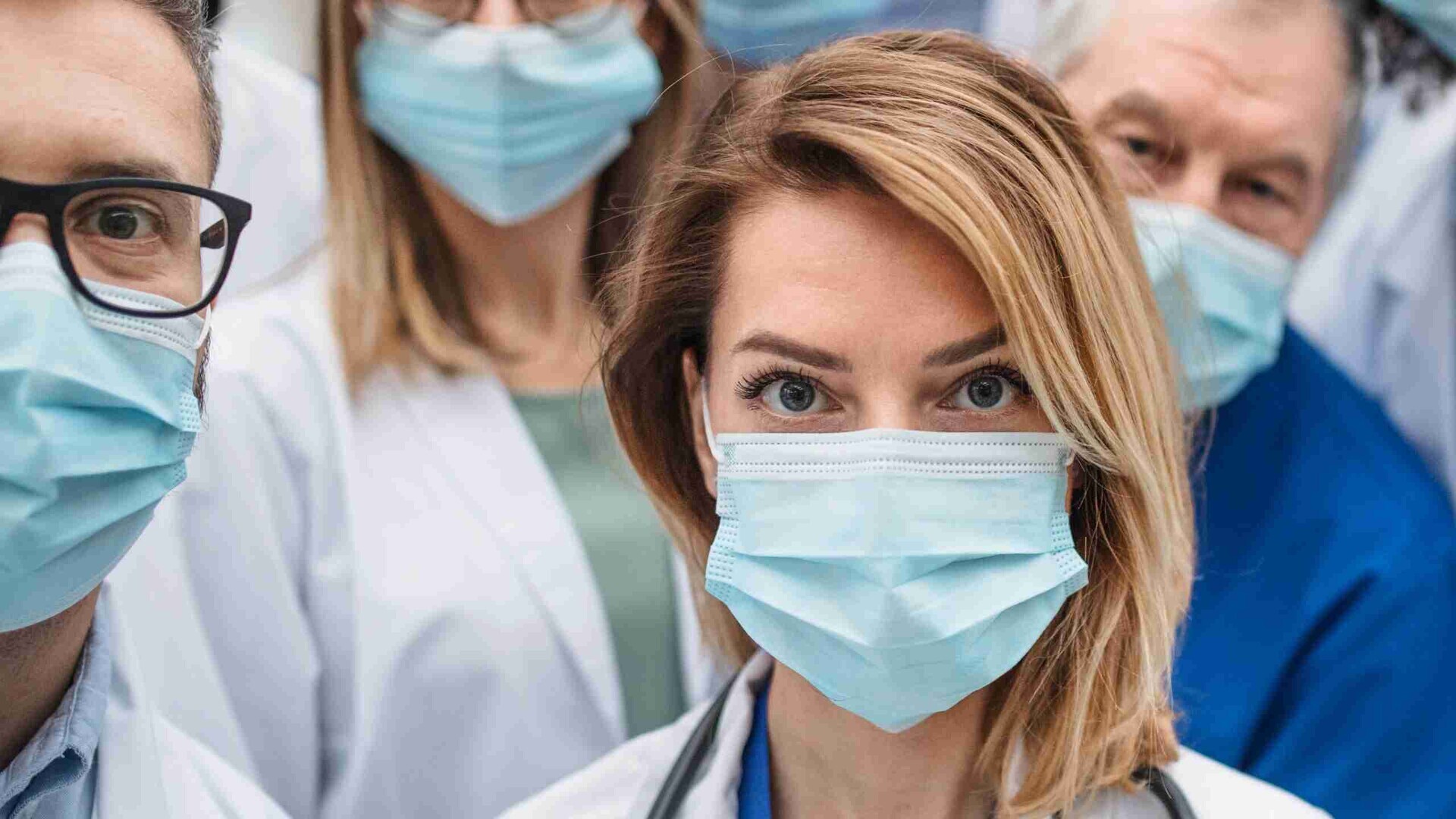 Eine gruppe von Ärzten mit OP-Masken schaut in die Kamera.