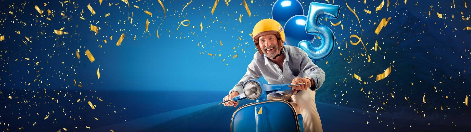 Gut gelaunter Mann sitzt auf einem Mofa mit Ballons