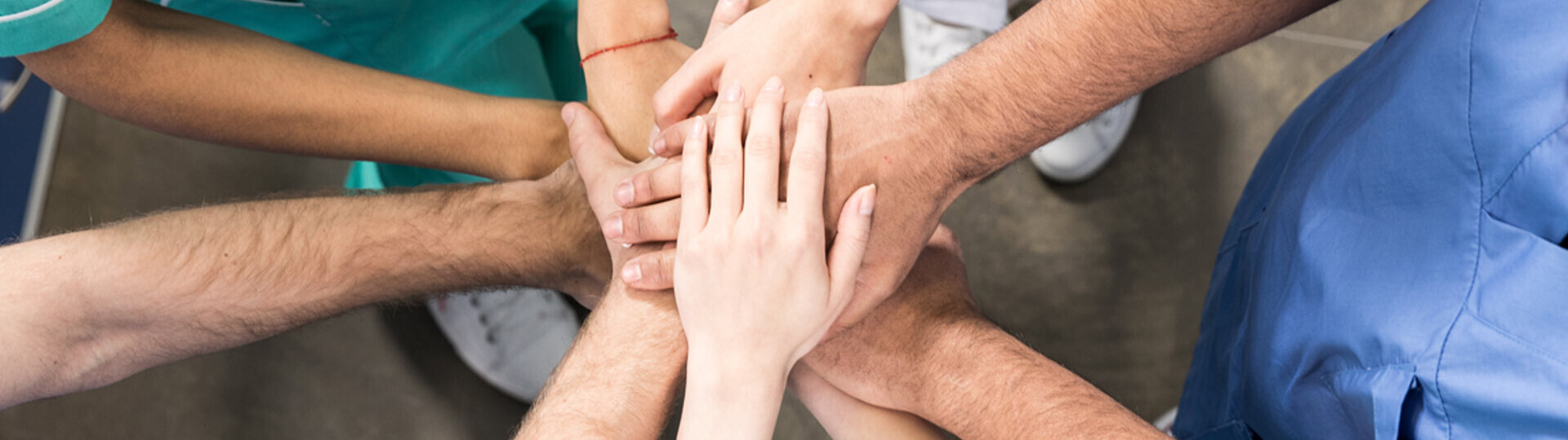 kollegen-halten-haende-zusammen-shutterstock-629115215-32zu9-1920x540px