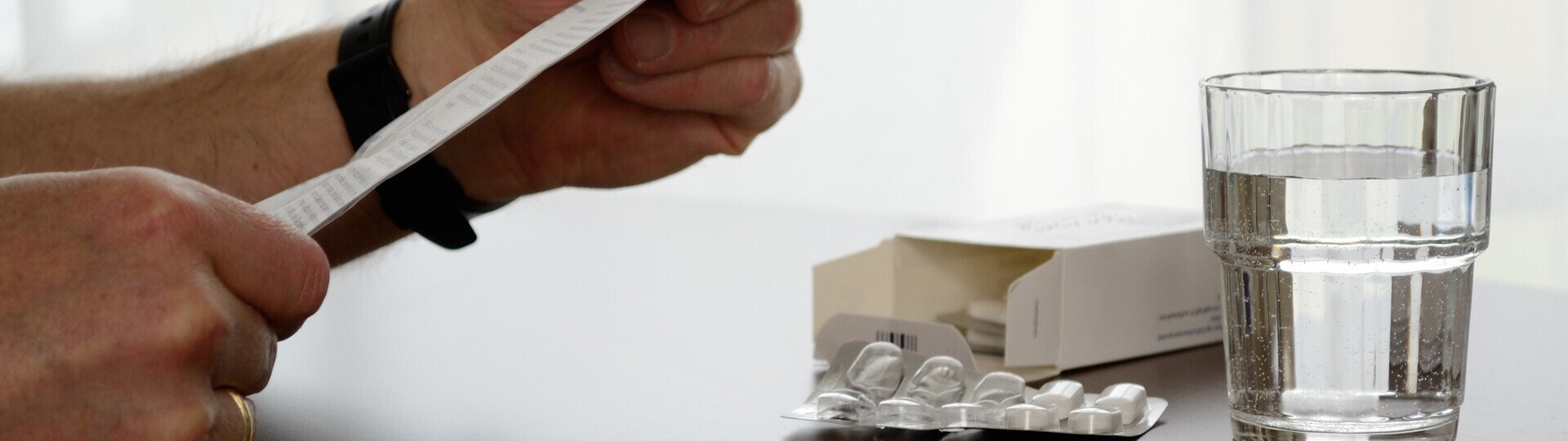 Person liest Beipackzettel von Medikament