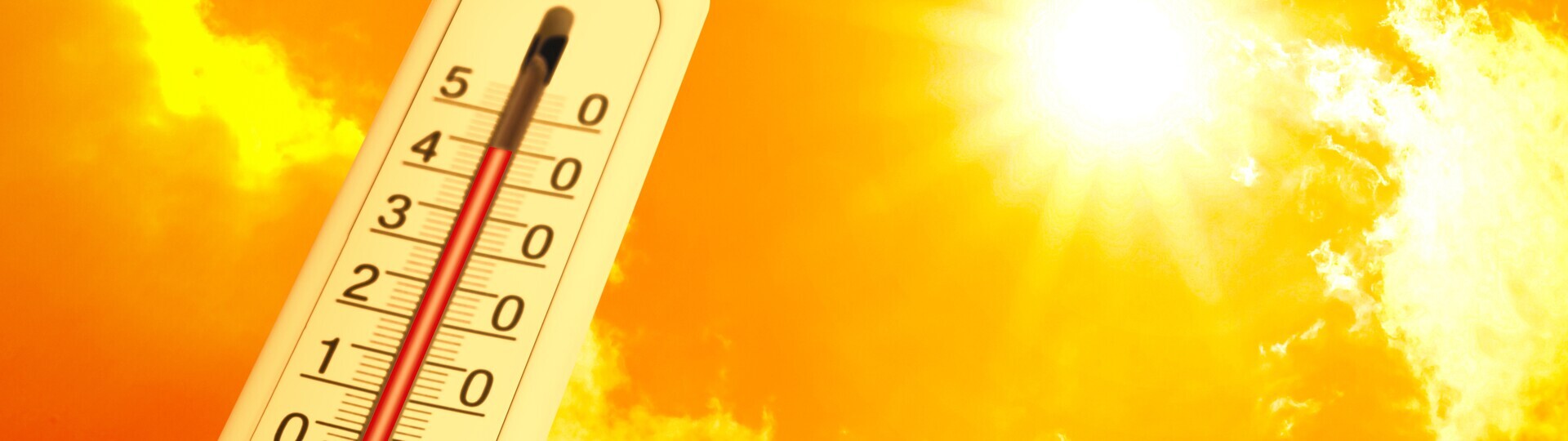 Extrem hohe Temperatur auf dem Thermometer vor orangefarbenem Himmel an einem sonnigen Tag.