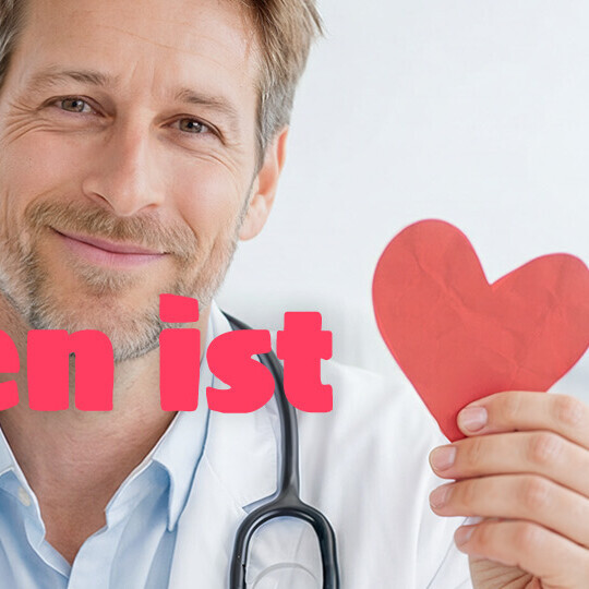 Lächelnder Arzt wirbt für die Kampagne "Impfen ist Herz-sache"