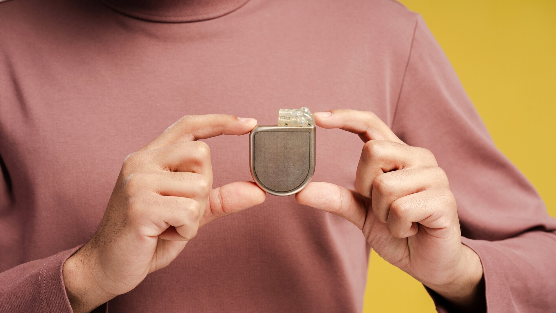 Mann mit Defibrillator-Implantat in der Hand