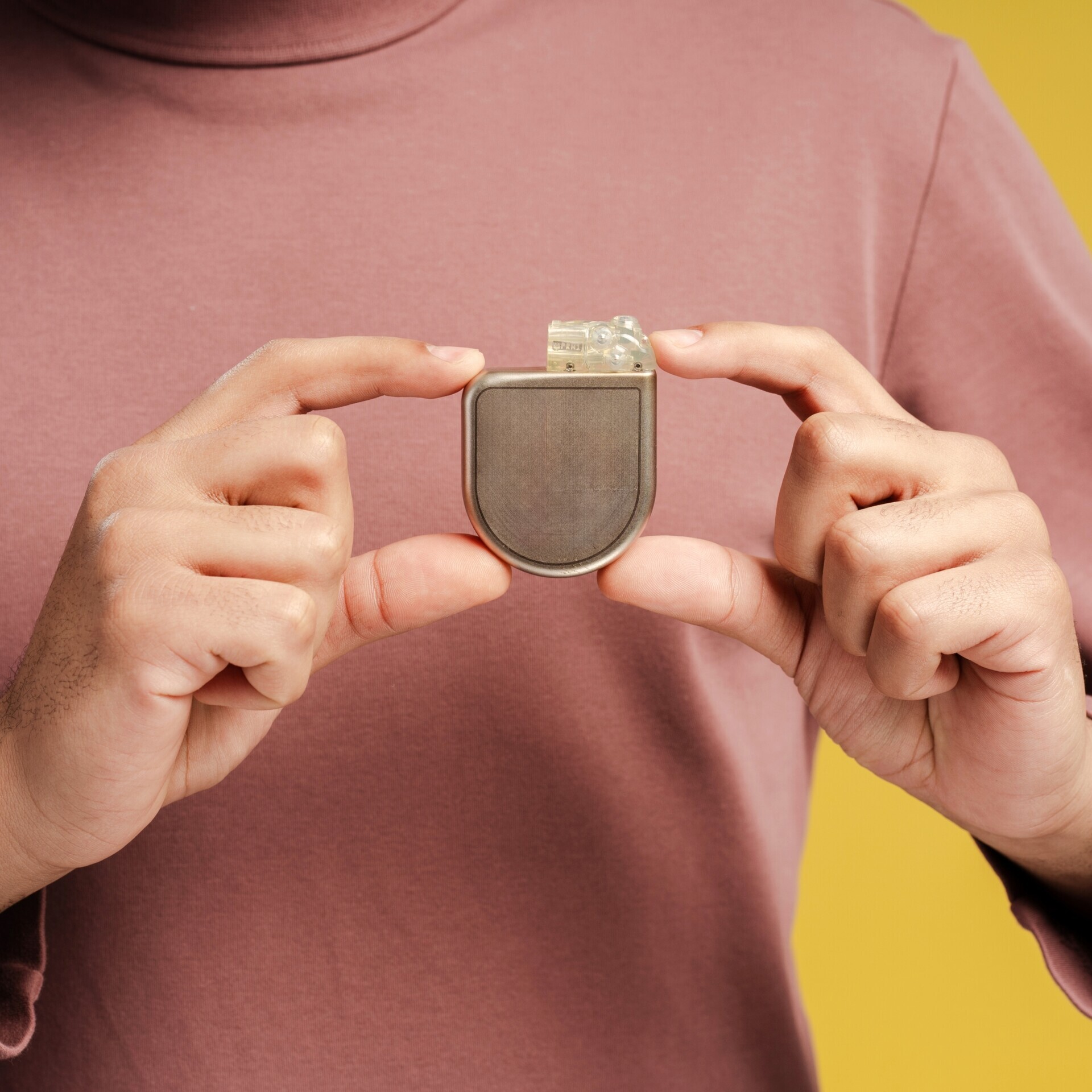 Mann mit Defibrillator-Implantat in der Hand