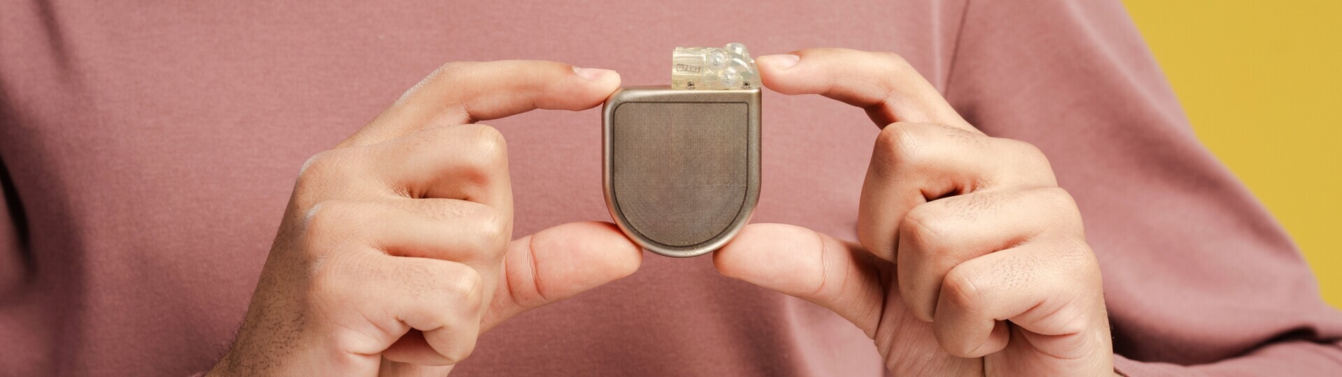 Mann mit Defibrillator-Implantat in der Hand