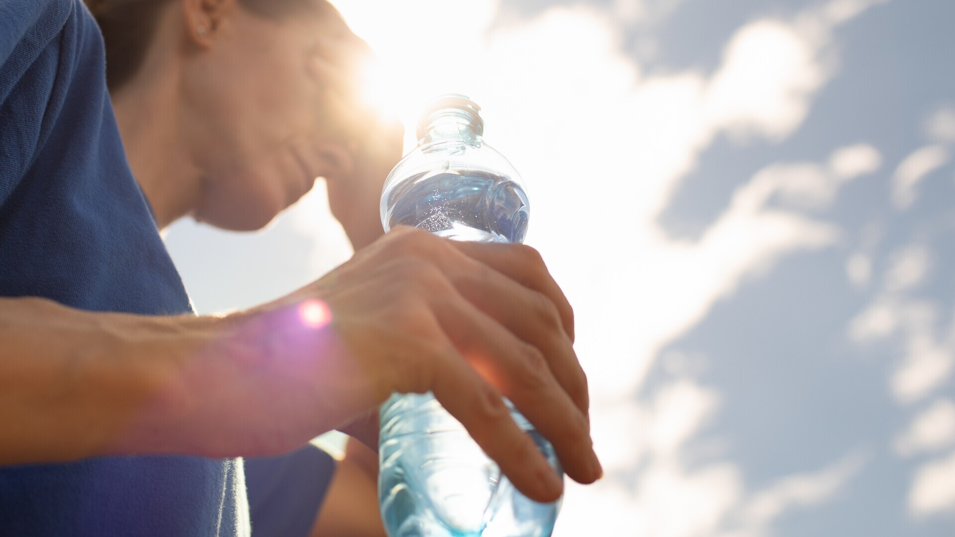 Frau trinkt Wasser bei Hitze