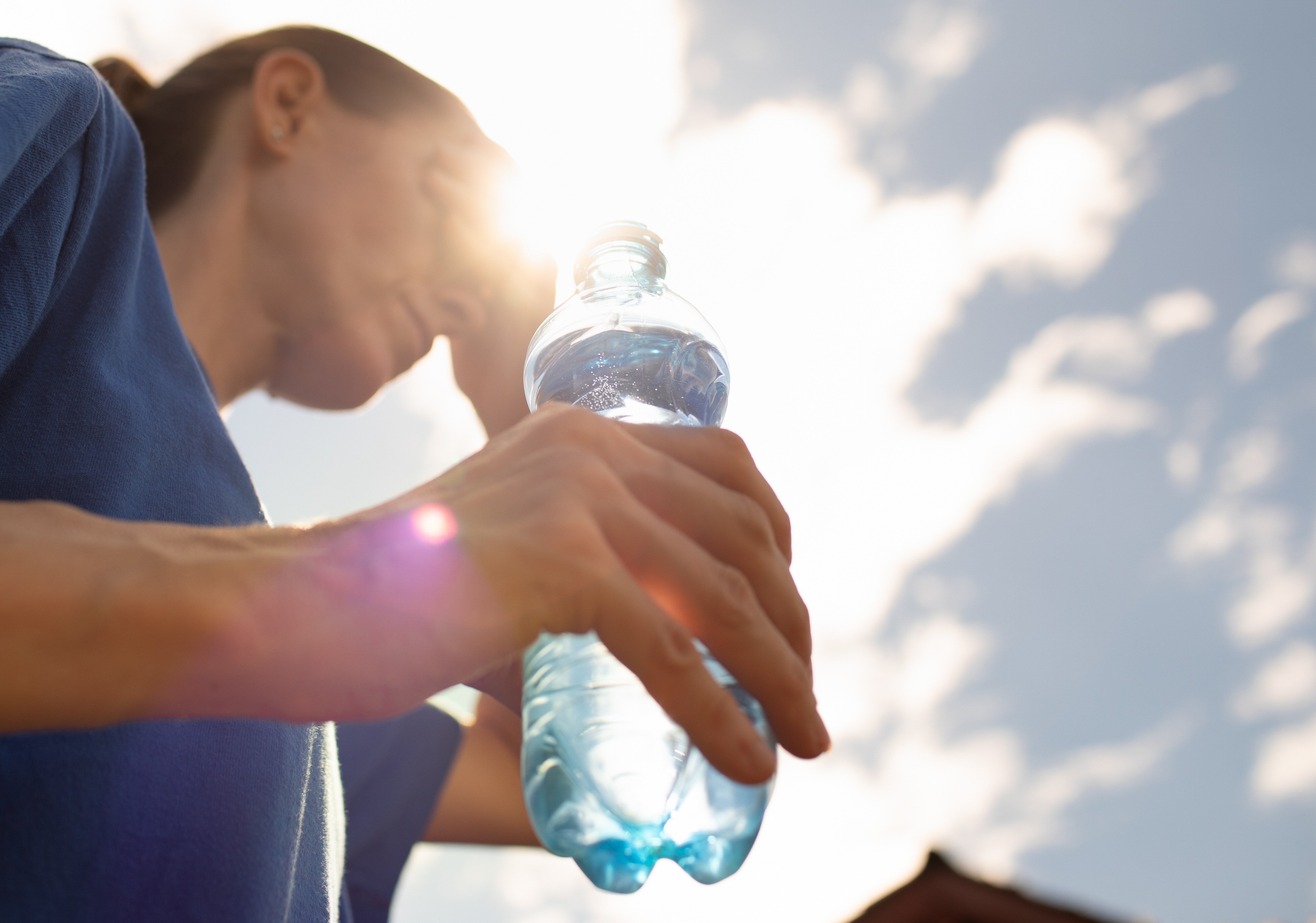 Frau trinkt Wasser bei Hitze