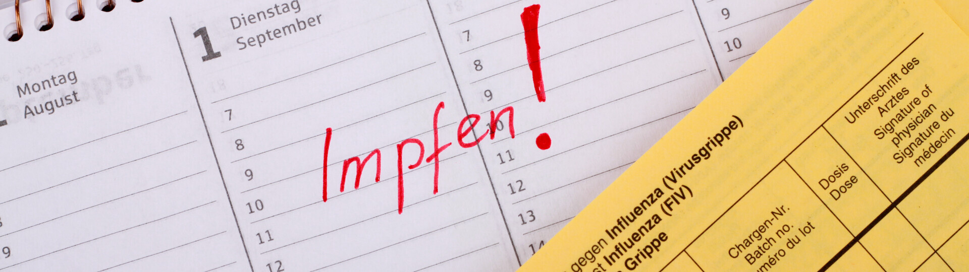 Impfpass liegt auf Kalender mit markierten Termin