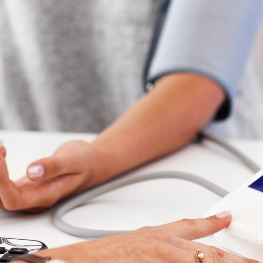 Ärztin misst Blutdruck bei Patientin