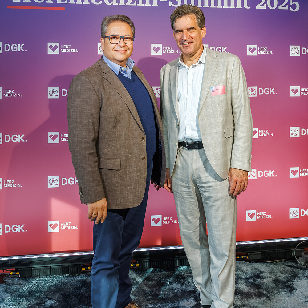Dr. Papoutsis (links) und Prof. Blankenberg (rechts) stehen vor der Fotowand des Herzmedizin Summits