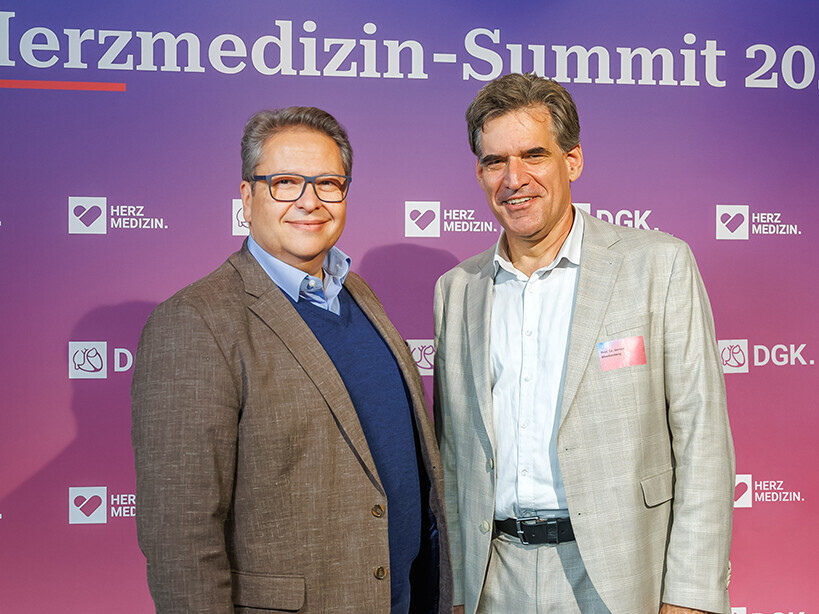 Dr. Papoutsis (links) und Prof. Blankenberg (rechts) stehen vor der Fotowand des Herzmedizin Summits